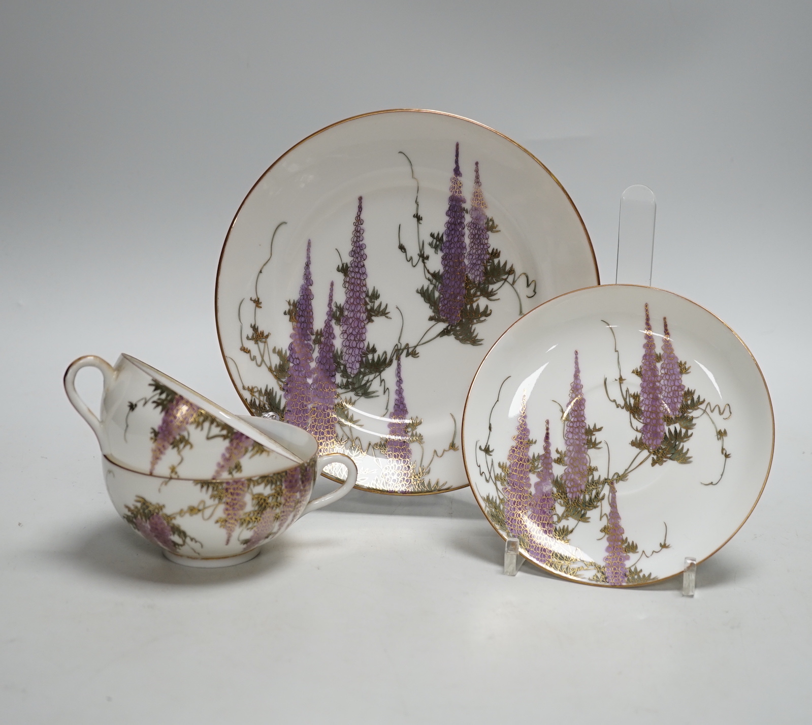 A Japanese part tea service with wisteria decoration, comprising of eight cups, eleven saucers and twelve tea plates
